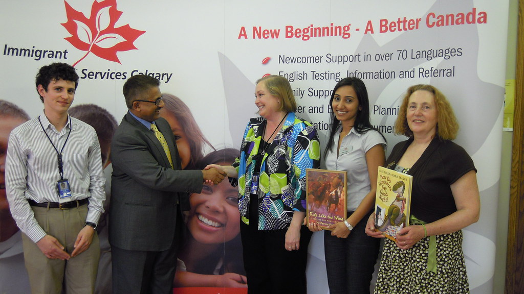 US Vice Consul Cassy Allen donating books to Immigrant Services Calgary