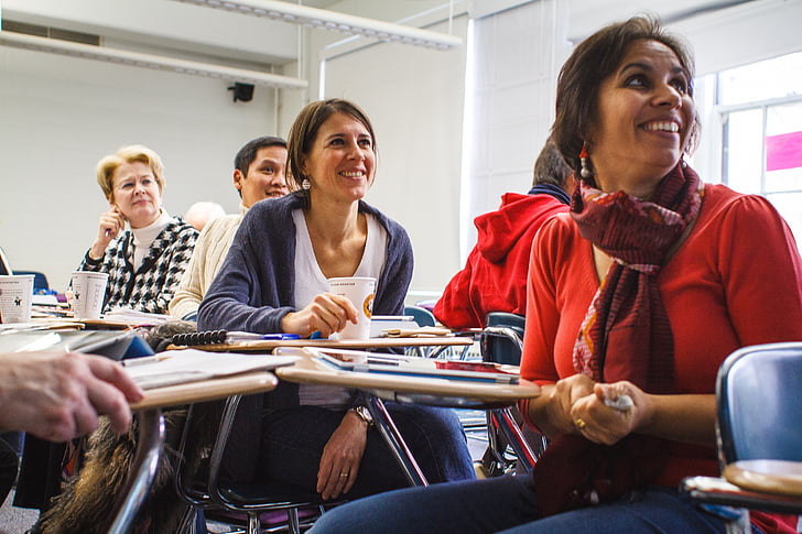 Participants in a professional training workshop classroom smiling.