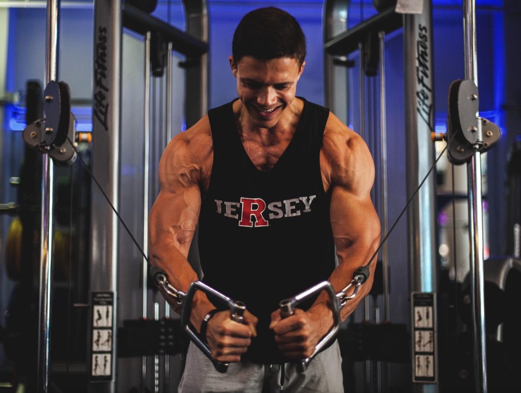 a muscular looking man is working out on machines for resistance exercise