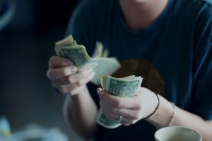 Woman counting dollar bills.