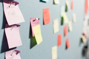 assorted sticky notes pinned to a board