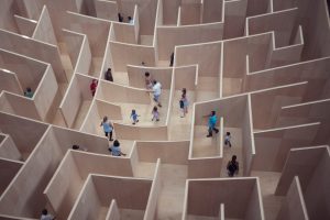 a group of people wandering through a maze, bird's eye view