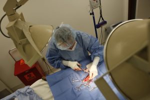Photograph of an operating room from above showing person involved in operation