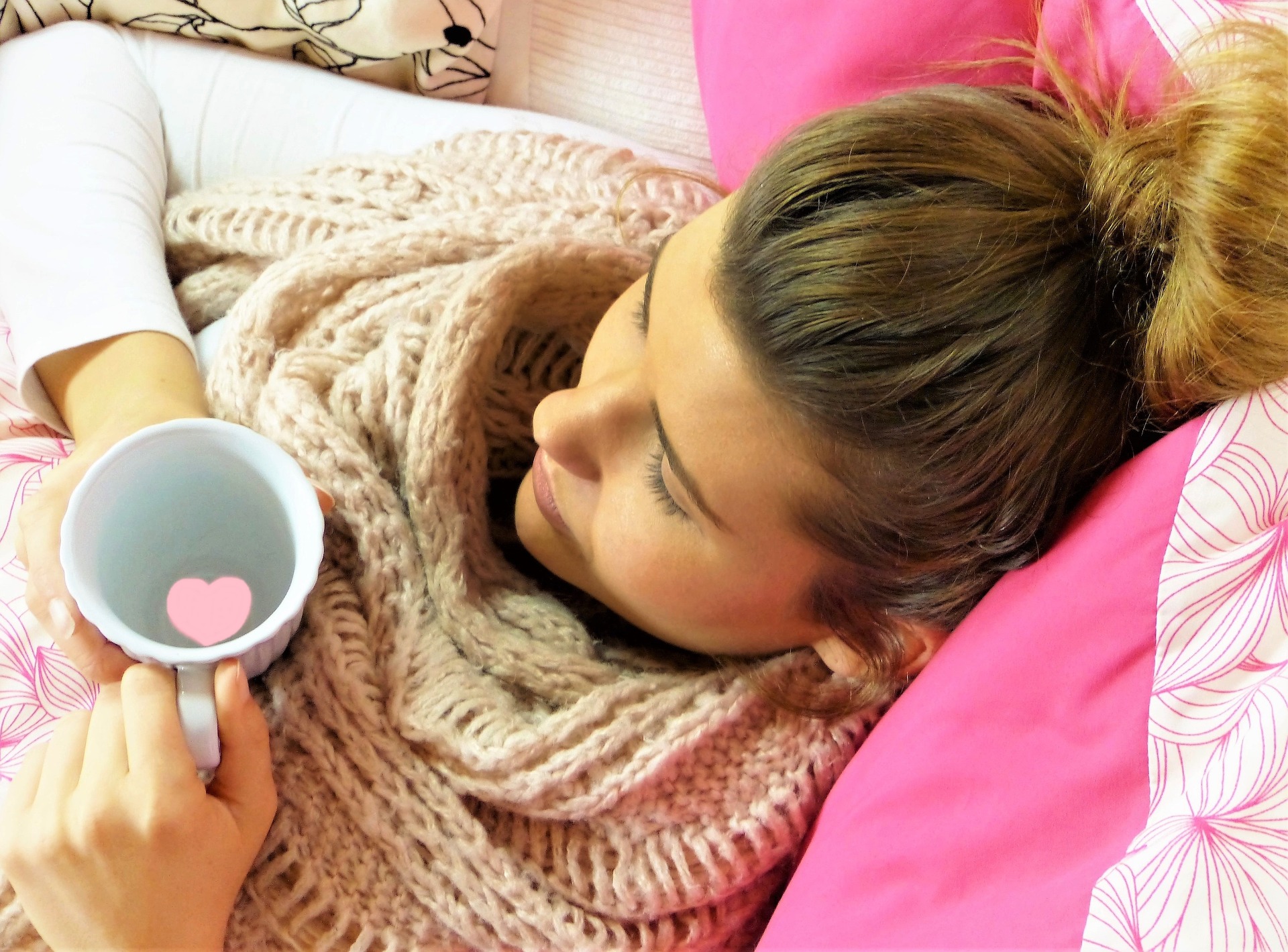 lady laying in bed with a cup of tea