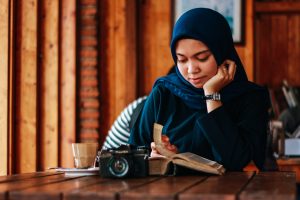 woman reading in a cafe with a camera on the table too