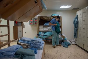 Image of worker folding hospital issued scrubs
