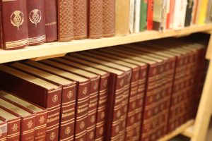 A volume of hard cover books on a bookshelf