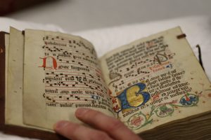 Medieval manuscript book with handwritten text and decorative elements