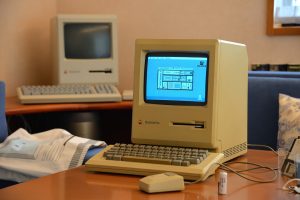 Macintosh plus all-in-one computer sitting on a wooden desk