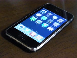 iPhone smartphone with touch screen display laying flat on table