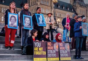 Protesters holding signs about Missing and Murdered Indigenous Women and Girls in Canada