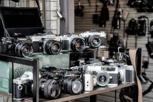 Black and grey cameras on shelf in a camera store