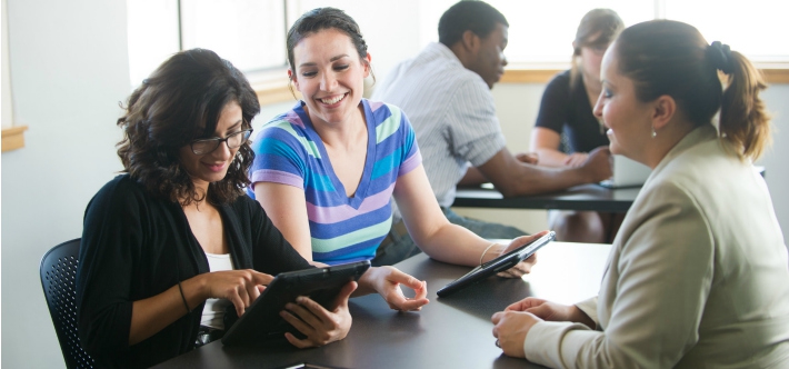 Descriptive image showing a large group of business professionals seated at a conference table for a meeting.