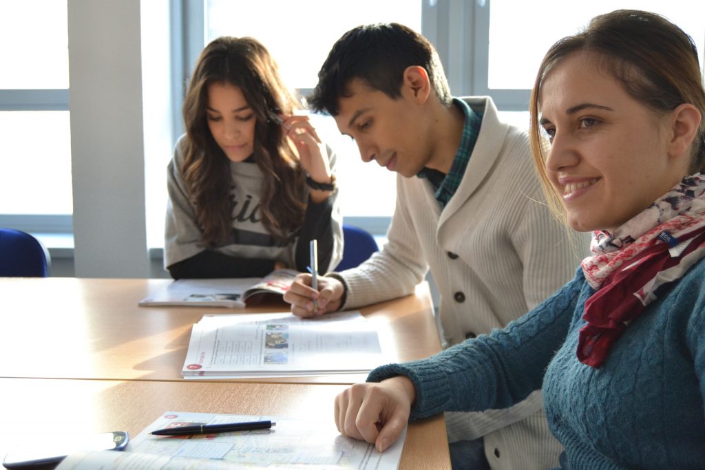 Descriptive image showing a group of young professionals, seated at a table together.